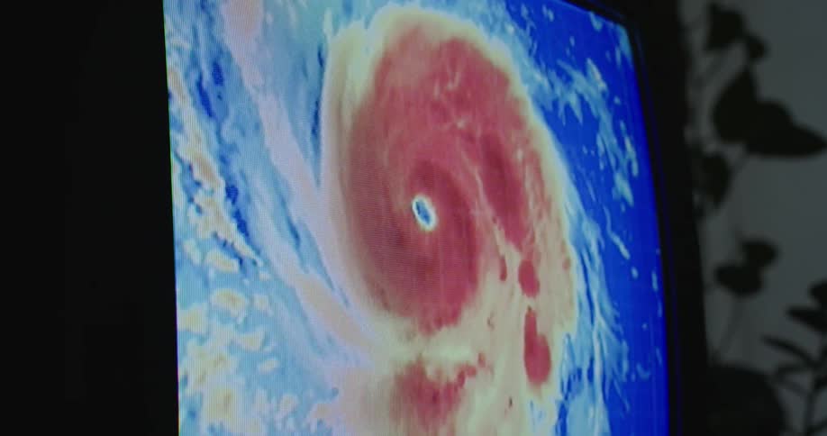 Close up of a television screen showing news about a hurricane