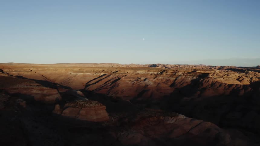 Tall canyons cast dark shadows onto the valley below