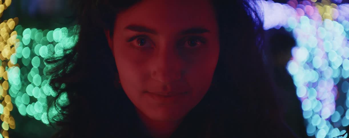 Female standing in light structure