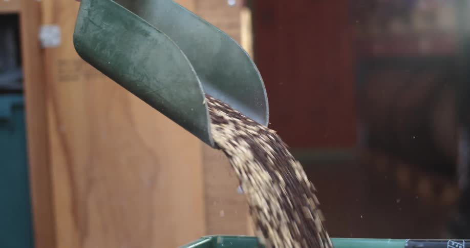 A person pours barley into the container