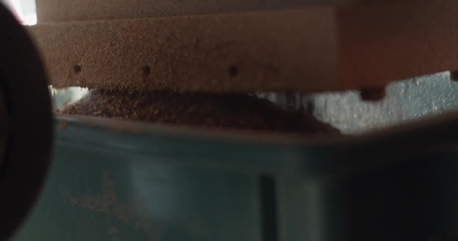 An industrial machine grinding coffee beans