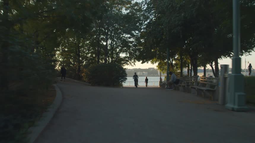 Man riding a bicycle on a crowded park near the coast in the city at morning
