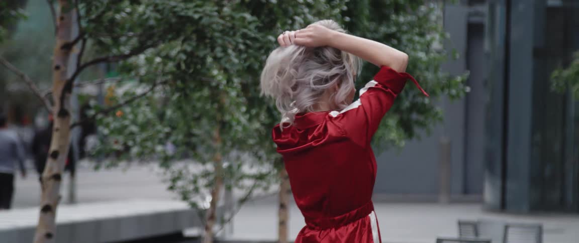 A model spins while posing in front of the building