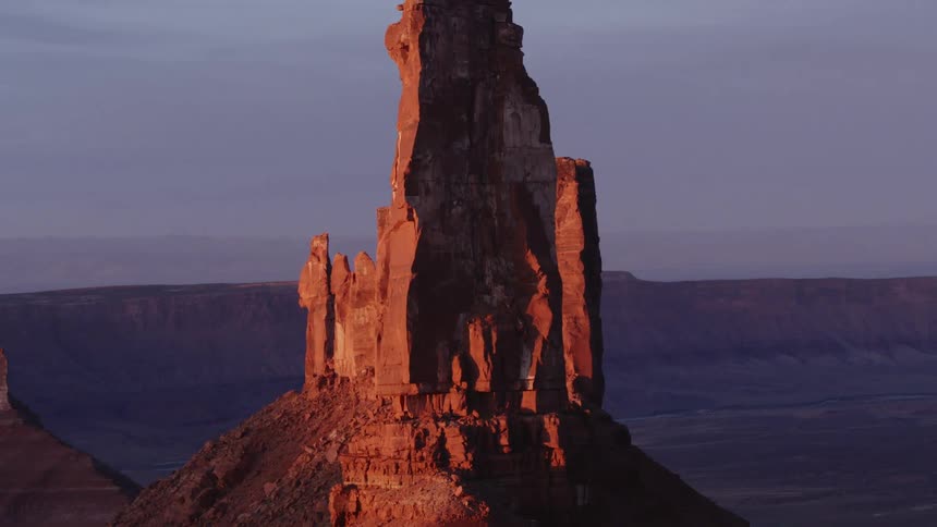 The sun shines on tall rock formations high in the sky
