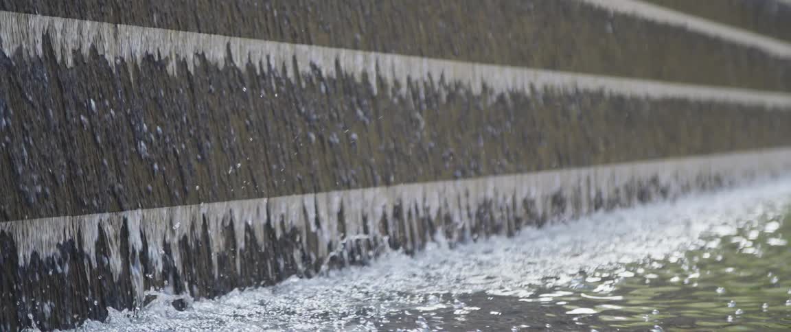 Water flows down wall to splash into pool