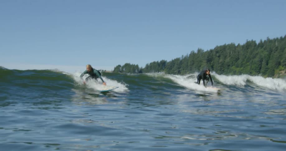 Three people are surfing near the shore