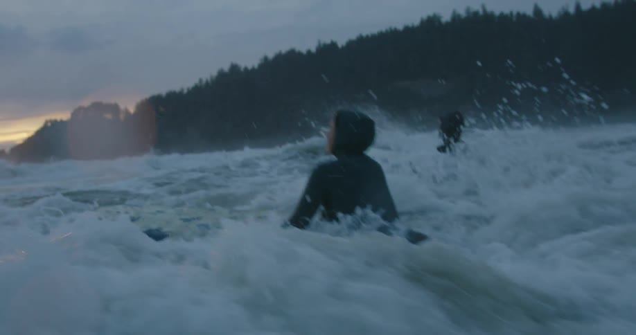 Two surfers fight their way into the tough surf