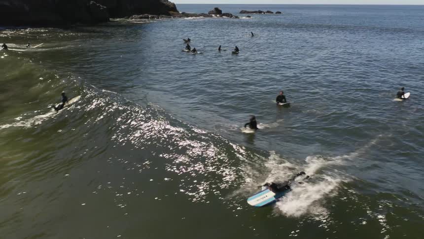 An aerial view of people on surfboards in the ocean