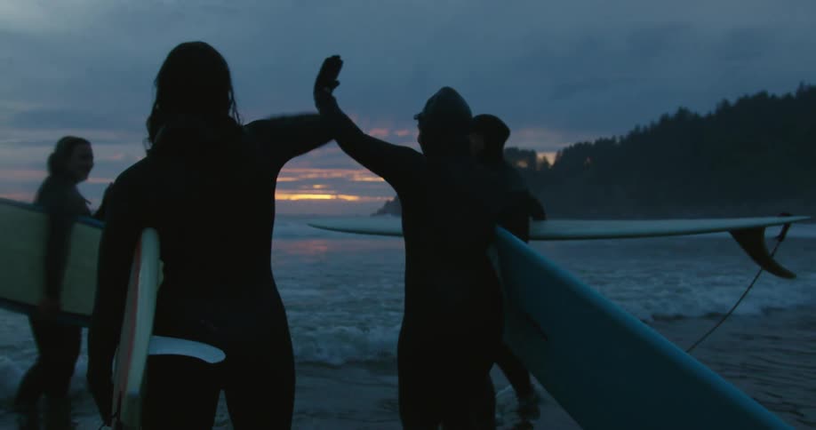 A group of surfers greeting each other at the beach