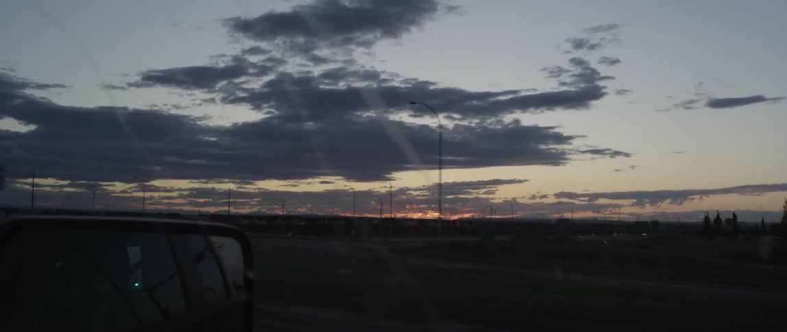 Traveling view of an empty field at sunset