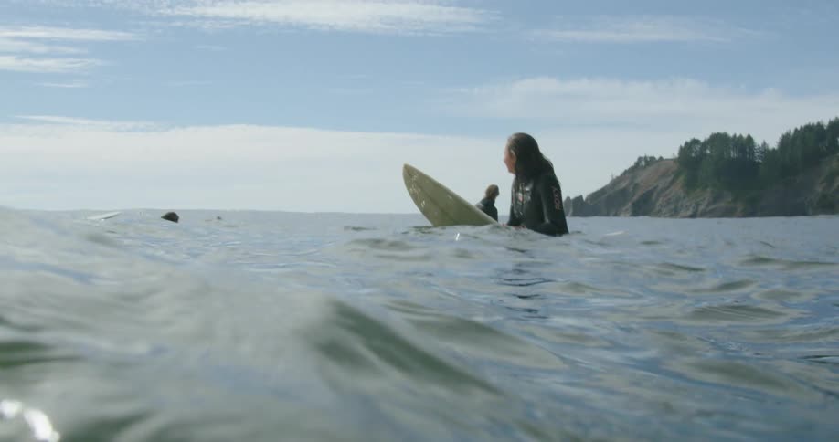 A group of friends are surfing on ocean water