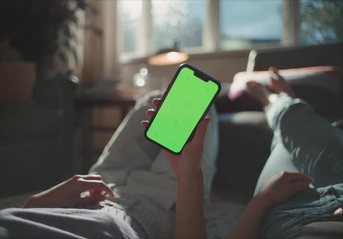 Person holding green phone lying down