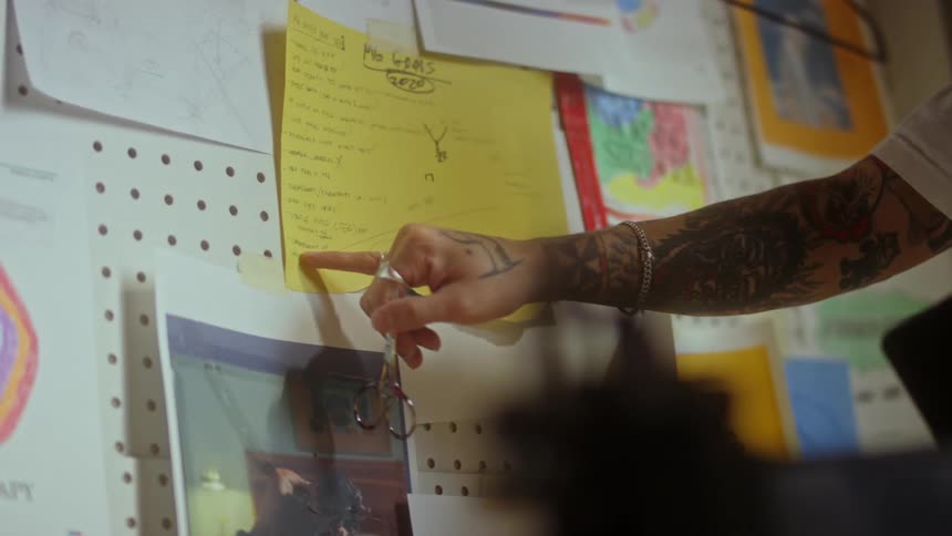 A tour guide talks as he points at a sign on a large board