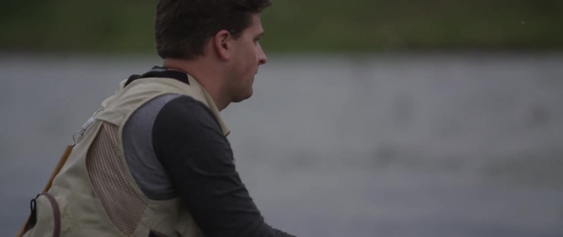 A man is fly fishing in the middle of a lake