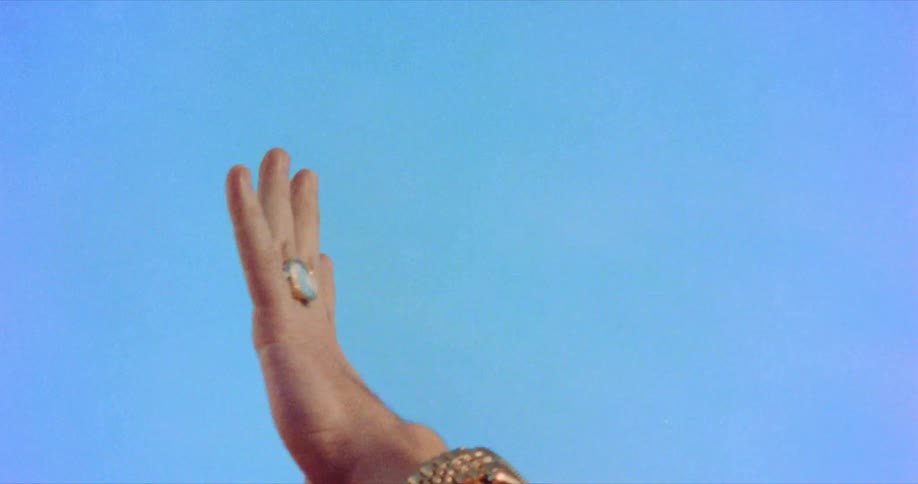 A woman wearing heavy jewelry enthusiastically high fives a man