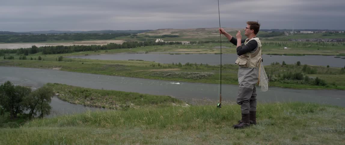 A man adjusts his fishing pole