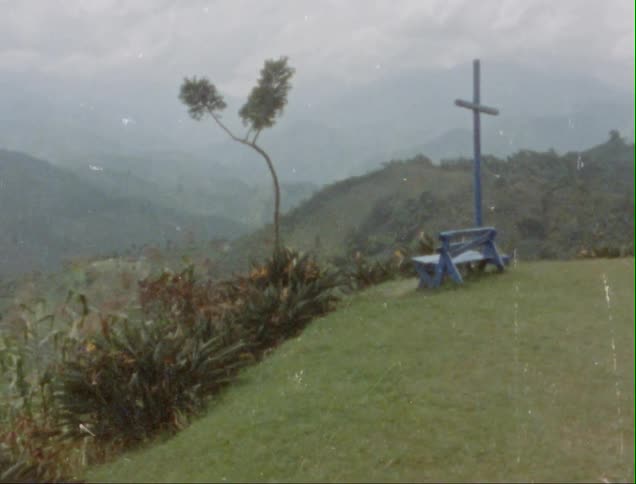 Blue bench on a scenic viewpoint at the edge of a garden in the mountains caught on vintage film