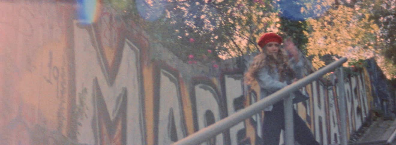 Young blonde woman energetically dancing on a stairway in the city at morning