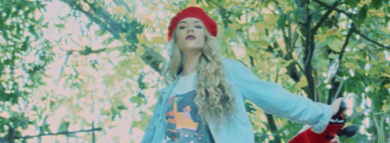 Woman wearing red beret poses near red motorcycle