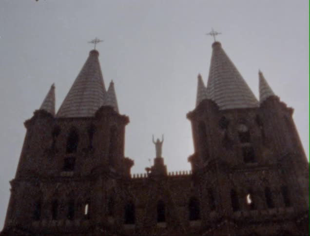 Facade of a the towers and sculptures of a church caught on vintage film