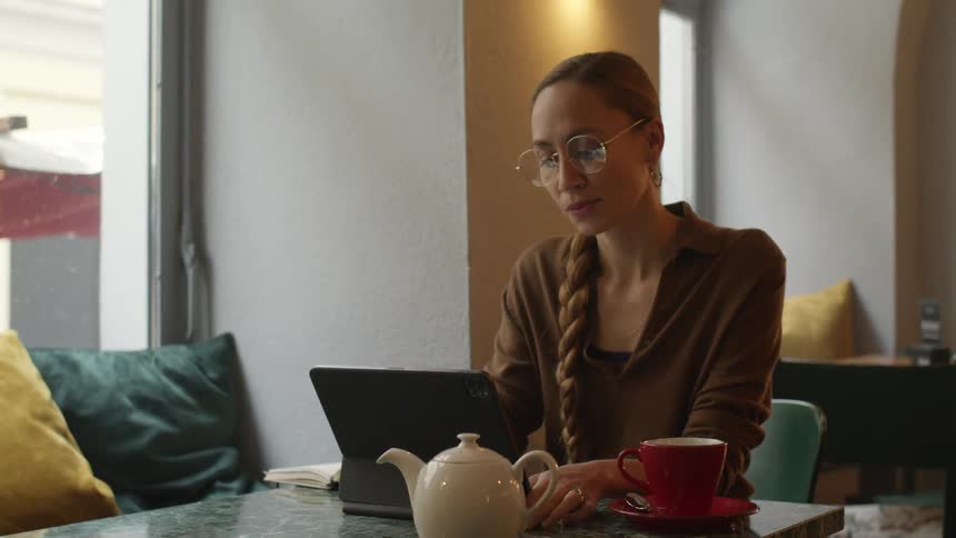 A woman using a laptop in a room looking out of the window
