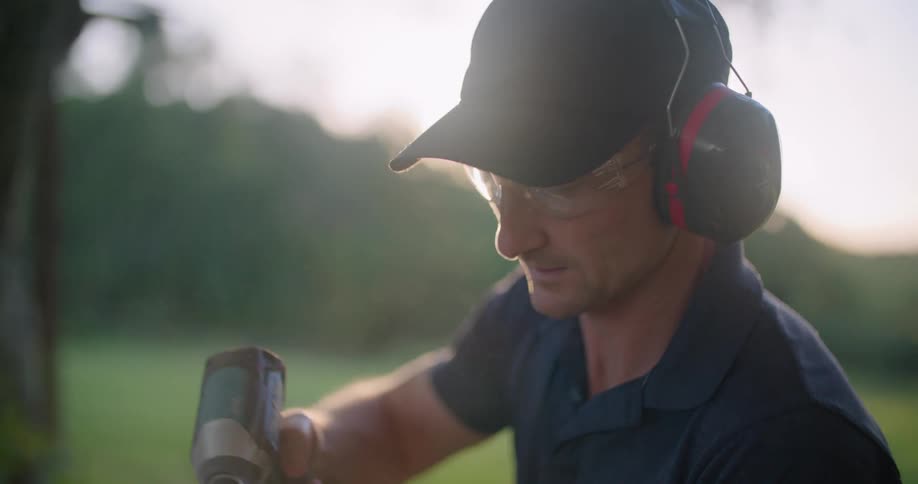 A man is sanding wood in his yard