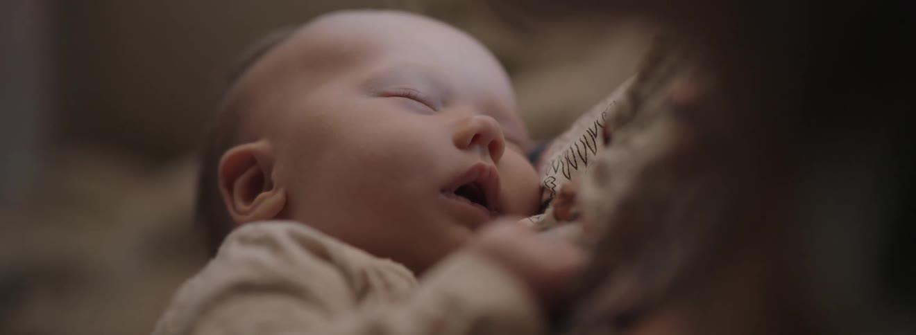 A baby is sound asleep in its mothers arms