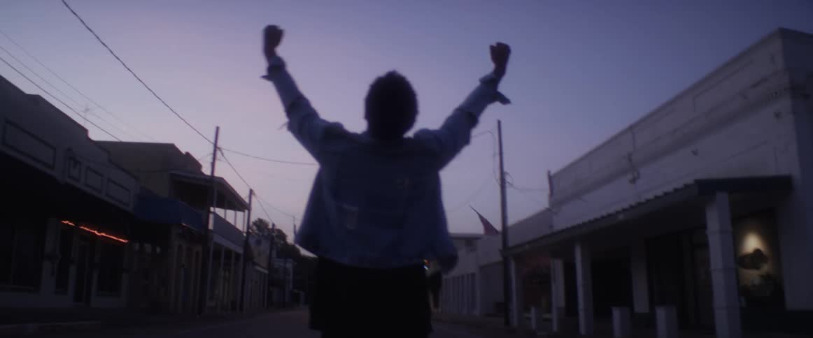 A man walks down the empty street waving his arms