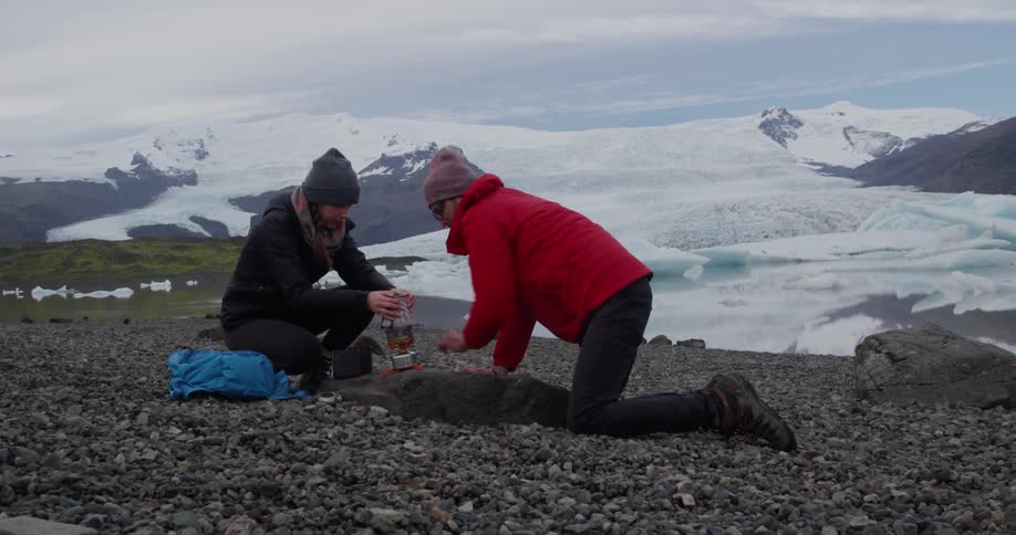 Two people are lighting a torch to heat up a drink