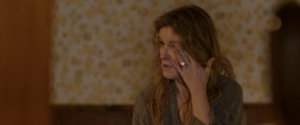 A woman wipes a tear from her eye