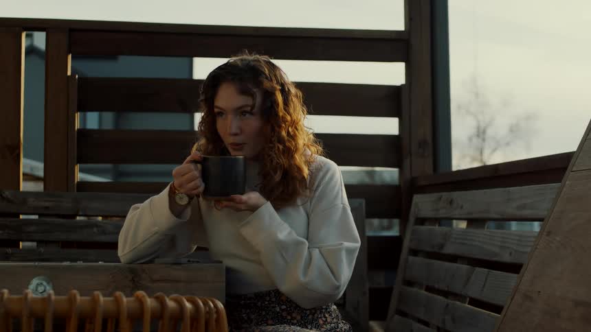 Female drinking from mug outdoors