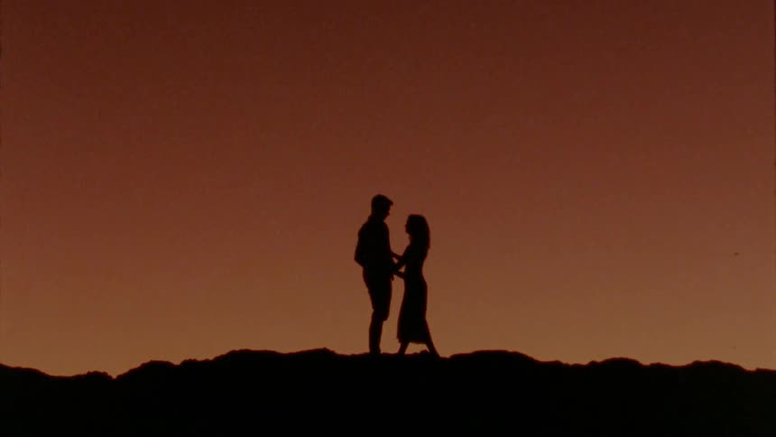 A man and woman hugging each other outdoors