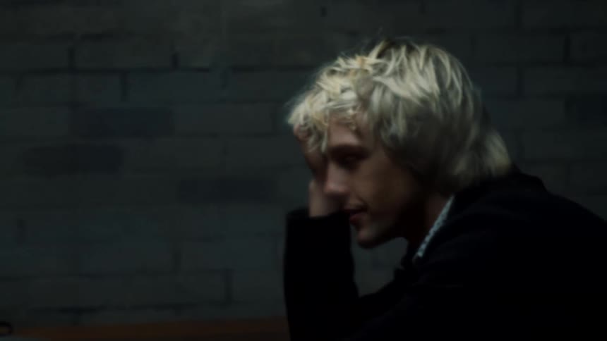 Two men talk in the dark room