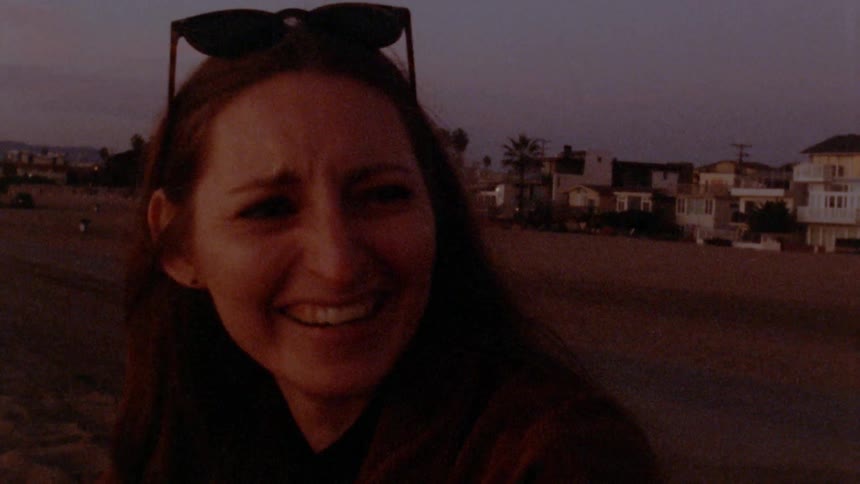 A woman laughs outside