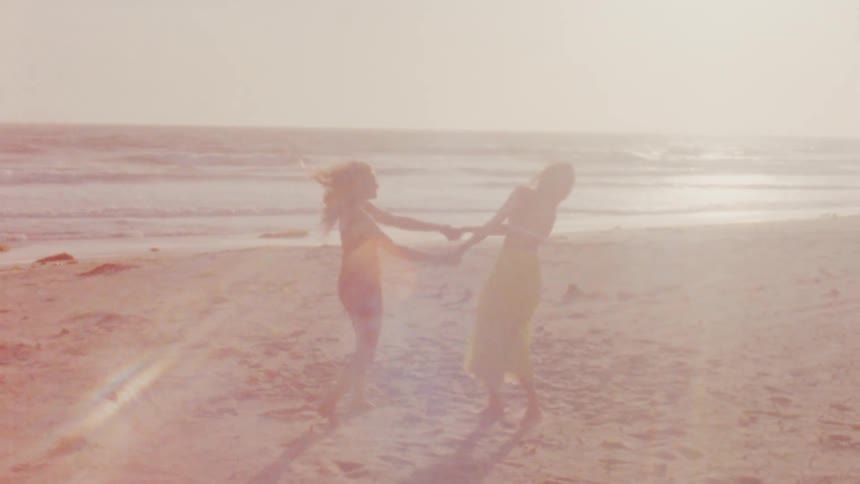 A view of two women dancing on the beach