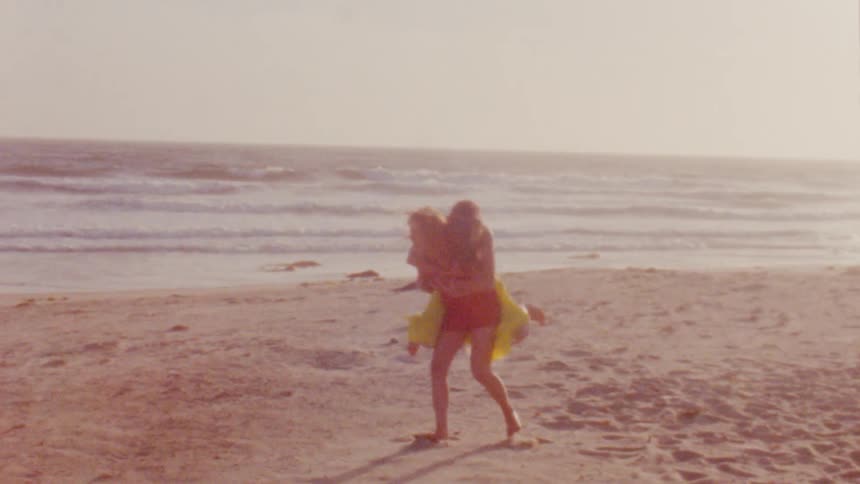 Two females play around together on a quiet beach