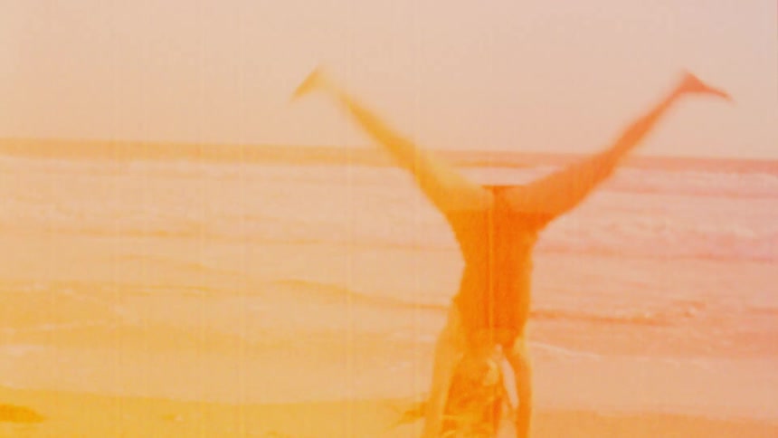 A woman is exercising outdoors by the beach