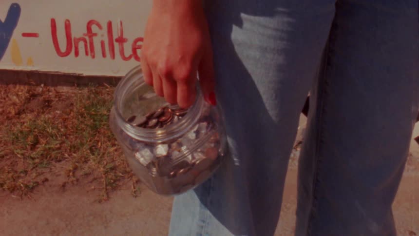 Woman with jeans and shirt holds coin jar