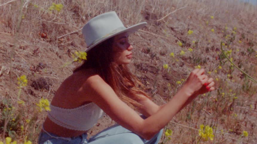 A woman is sittingo outdoors in the grass in spring
