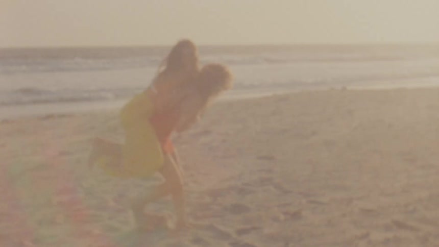 Two women running around outside on the beach
