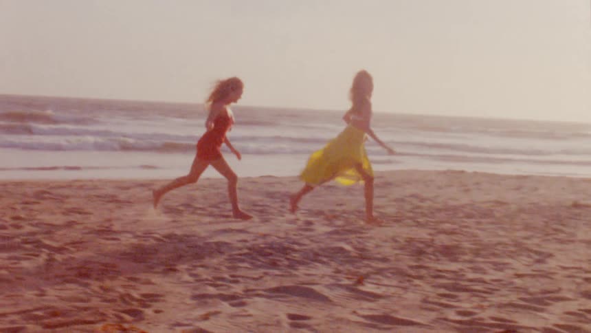 Two women are running around the beach at dusk