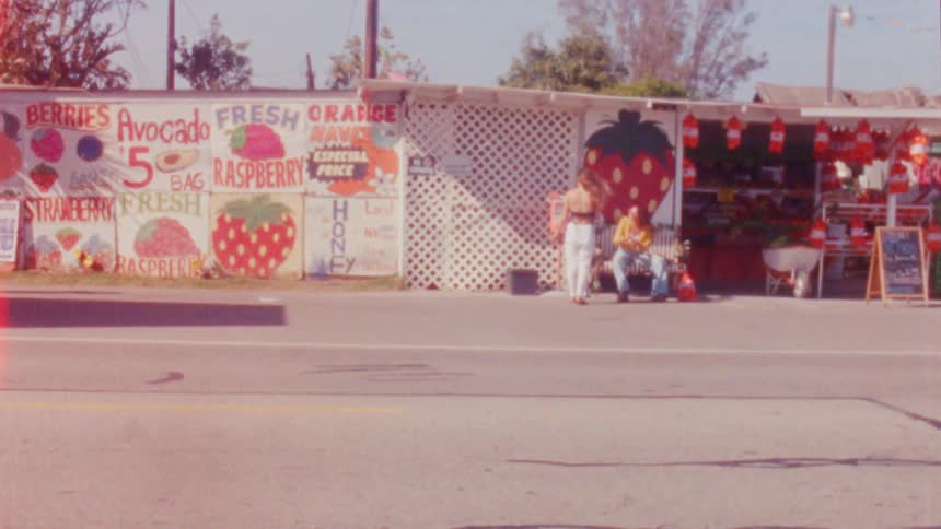 A view of people sitting next to the road on the middle of the day