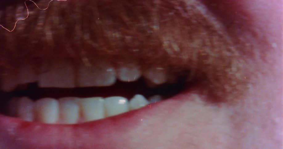 A man with a mustache is opening his mouth and moving his tongue