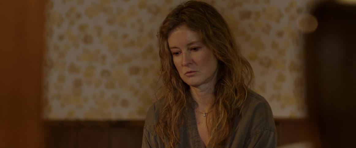 A woman nods off and struggles to stay awake while sitting at home