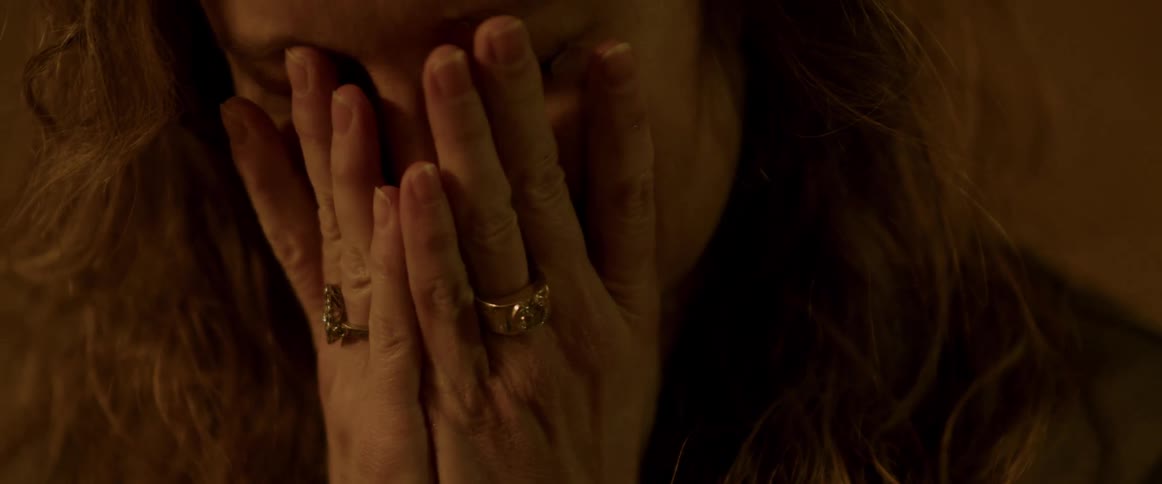 Closeup of a woman covering her face with hands and crying