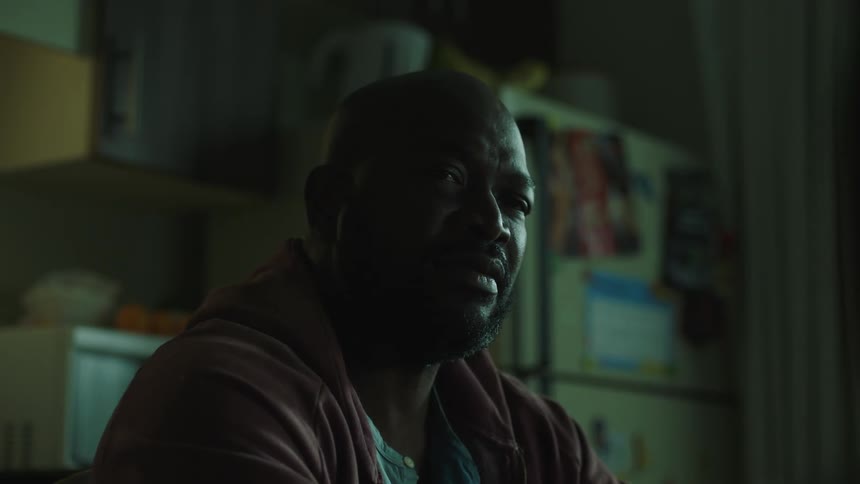 A man talks with someone in his kitchen