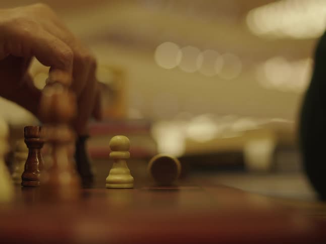 A person takes a chess piece during the game