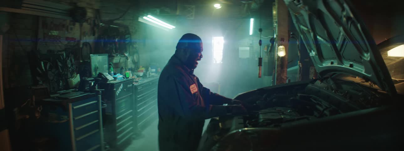 A mechanic gets frustrated while working on an engine