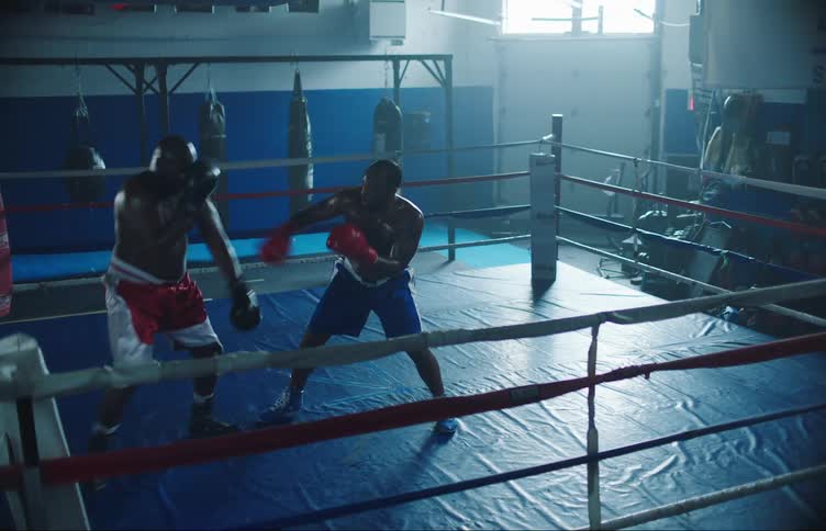 Two black men are fighting in a boxing ring