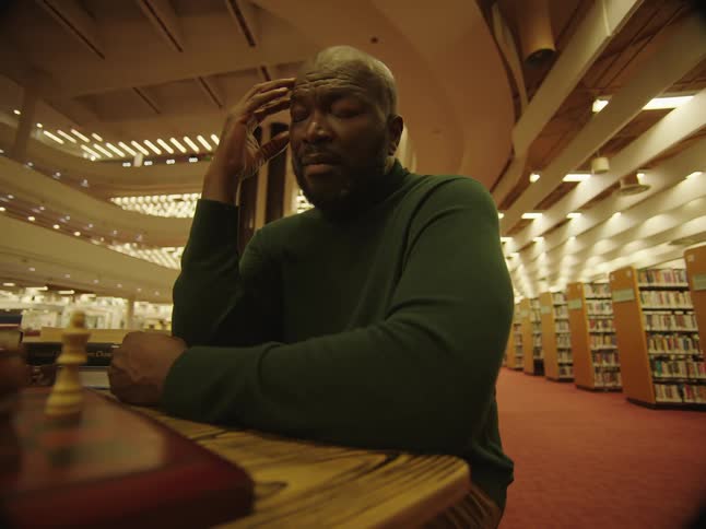 A man is sitting at a table in a library
